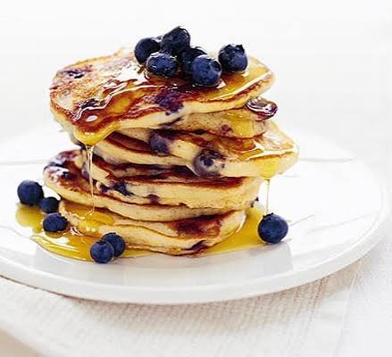 Fluffy blueberry pancakes stacked high with syrup